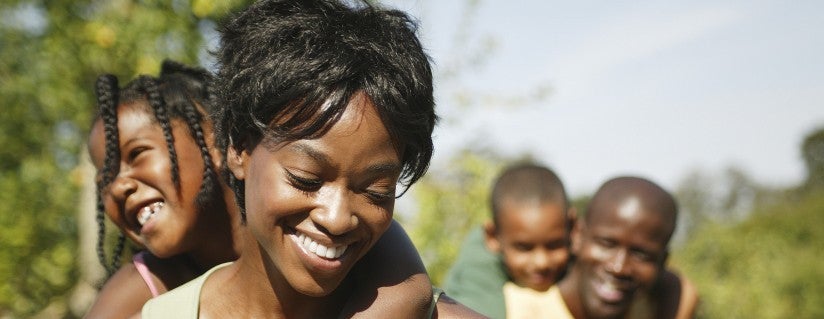 African American family with children being carried by parents 